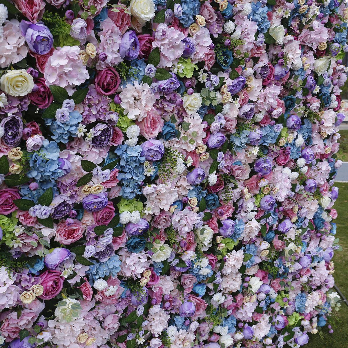 Simulovaná kvetinová stena s látkovým dnom na pozadí steny svadobná výzdoba interiéru a simulované kvety